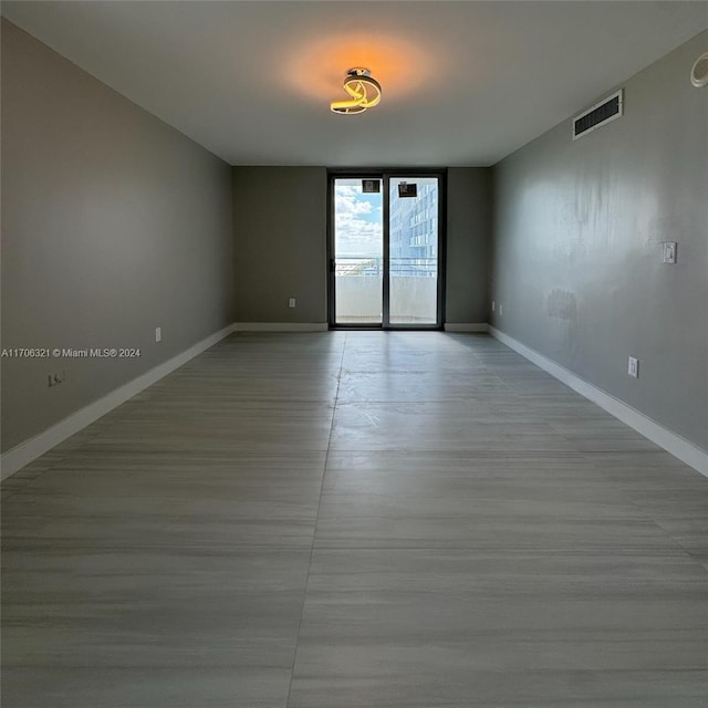 unfurnished room featuring floor to ceiling windows