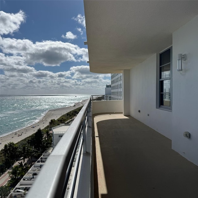 balcony featuring a water view and a beach view