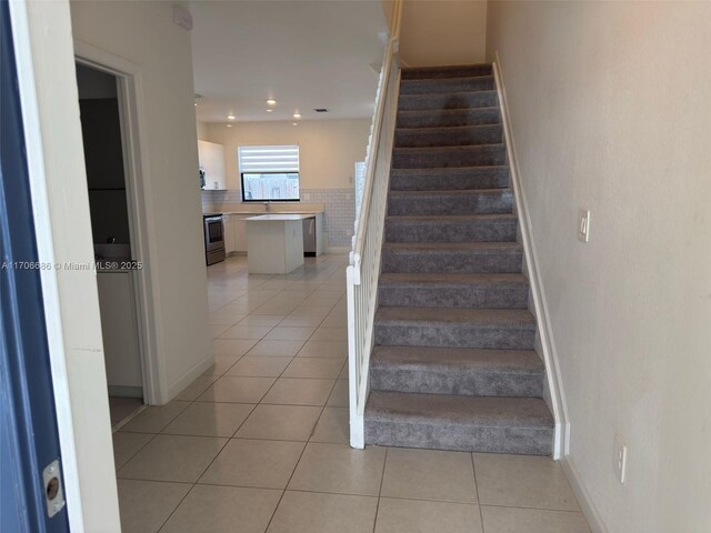 stairs featuring tile patterned floors and electric panel