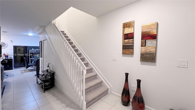 stairway featuring tile patterned flooring and baseboards