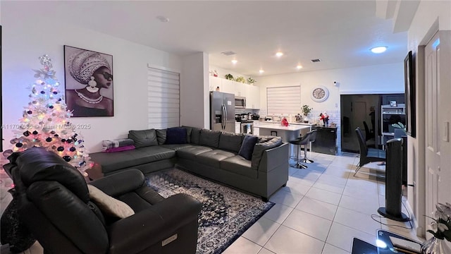 living room with light tile patterned floors, visible vents, and recessed lighting