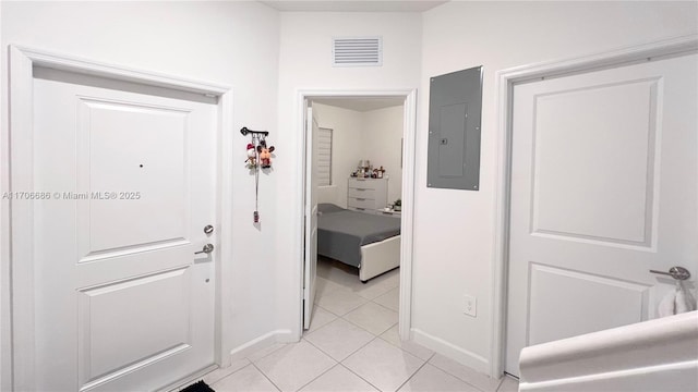 foyer featuring electric panel, light tile patterned floors, baseboards, and visible vents