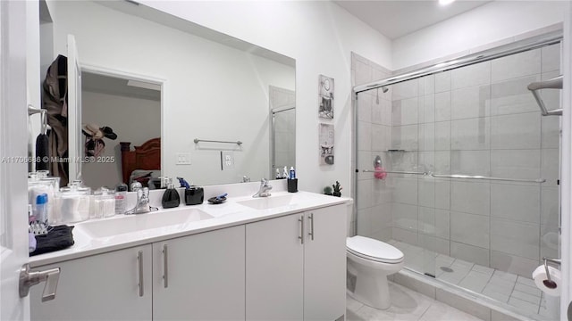 bathroom with a shower stall, toilet, double vanity, and a sink