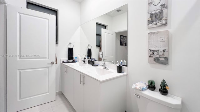 bathroom featuring a sink, visible vents, toilet, and double vanity