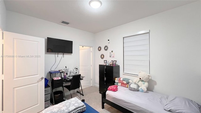 bedroom featuring visible vents and light carpet