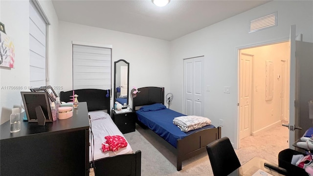 bedroom with a closet, visible vents, and carpet floors