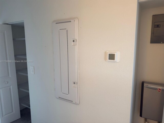 clothes washing area with light colored carpet and stacked washer and dryer