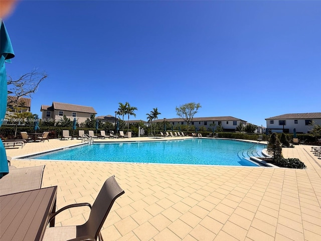 pool with a patio area and fence