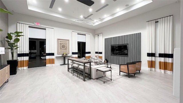 living area with visible vents, recessed lighting, baseboards, and a tray ceiling