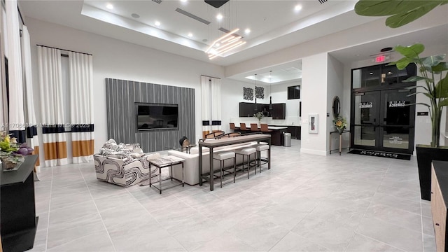 living area featuring light tile patterned flooring, recessed lighting, and a tray ceiling