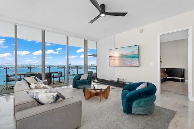 living room with ceiling fan, expansive windows, and a water view