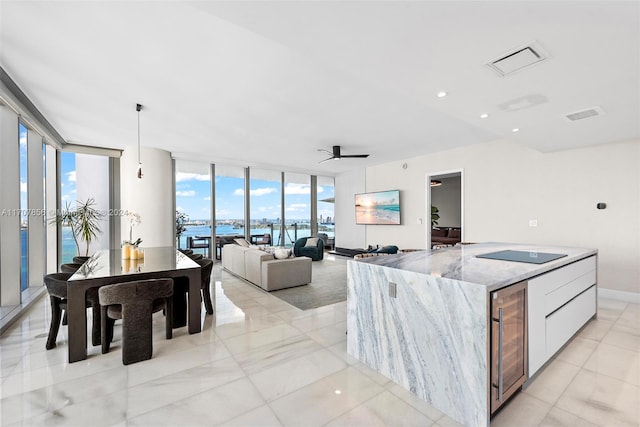 kitchen featuring white cabinets, ceiling fan, plenty of natural light, and beverage cooler