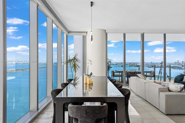 dining room featuring floor to ceiling windows and a water view