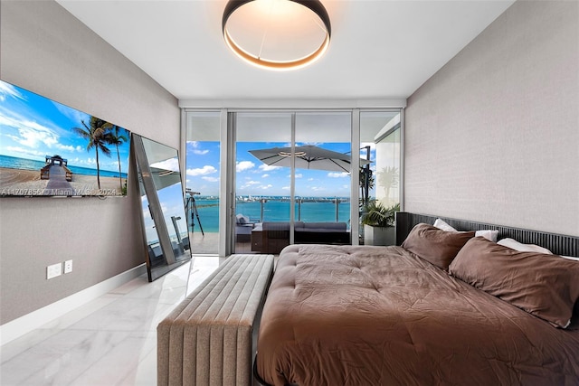 bedroom featuring access to outside, expansive windows, and a water view