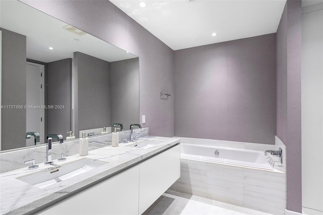 bathroom featuring vanity and a relaxing tiled tub