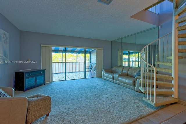 carpeted living room featuring a textured ceiling