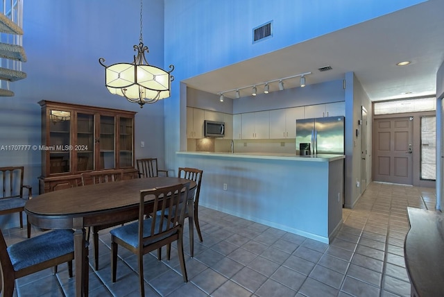 tiled dining space featuring a high ceiling