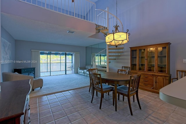 dining room featuring light carpet and a towering ceiling