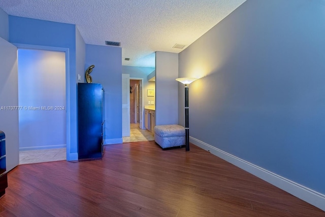 interior space featuring wood-type flooring and a textured ceiling