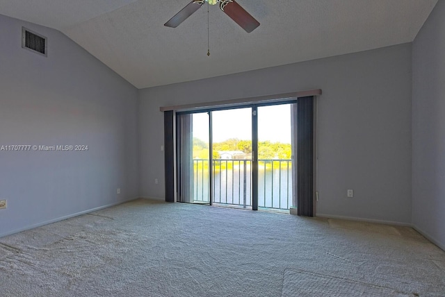 unfurnished room with carpet floors, a water view, vaulted ceiling, and ceiling fan