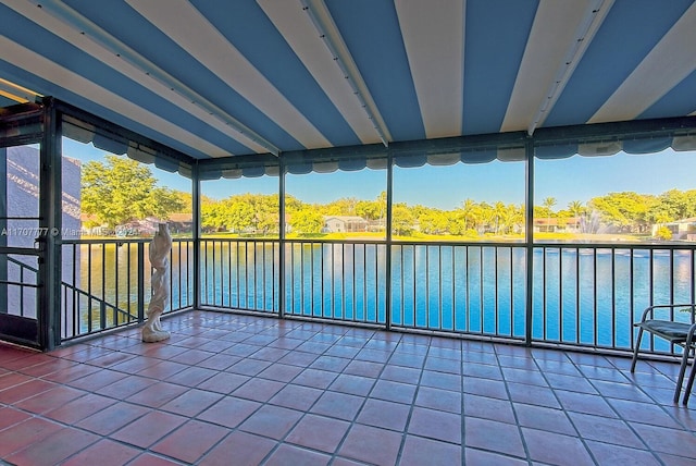 unfurnished sunroom featuring a water view