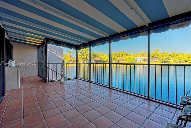 unfurnished sunroom with a water view