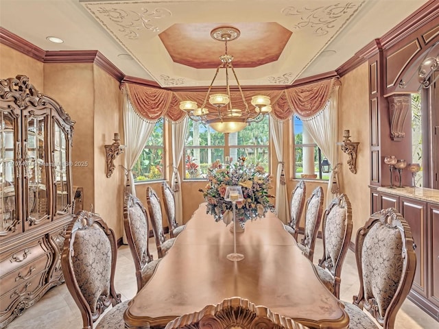 dining area with ornamental molding, a tray ceiling, light tile patterned floors, and an inviting chandelier