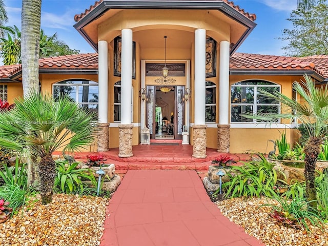 entrance to property with a tiled roof and stucco siding