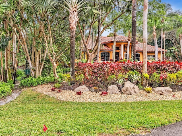 view of front of home with a front yard and a tiled roof