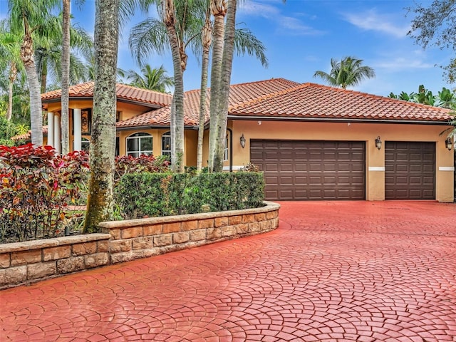 mediterranean / spanish home with a tiled roof and stucco siding