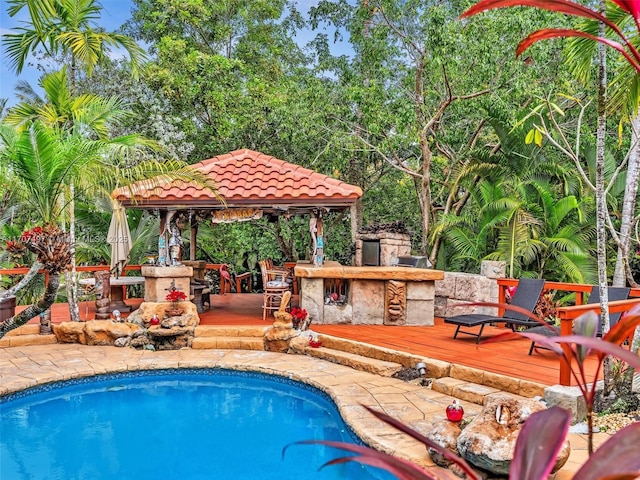 view of pool with a deck, a gazebo, and a bar