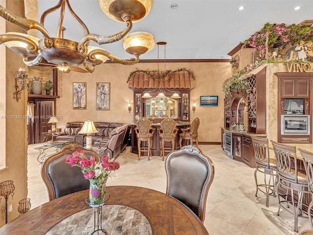 dining space with arched walkways, indoor bar, recessed lighting, ornamental molding, and baseboards