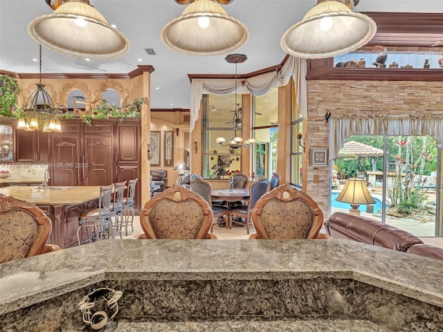 interior space featuring sink, pendant lighting, and crown molding