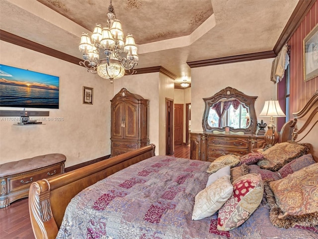 bedroom featuring an inviting chandelier, crown molding, dark hardwood / wood-style floors, and a tray ceiling