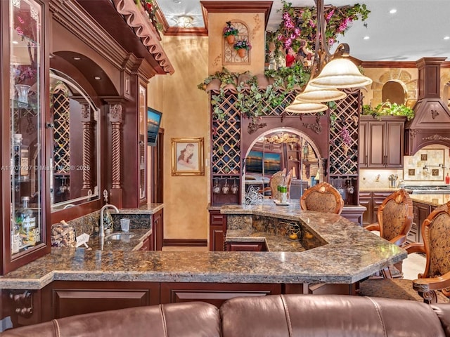 bar with indoor wet bar, crown molding, backsplash, and a sink