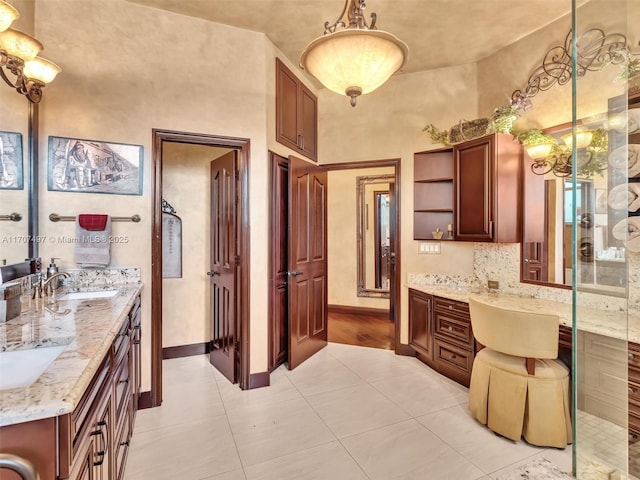 kitchen with light stone counters, sink, and pendant lighting