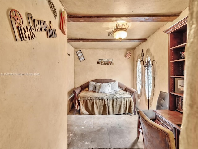 bedroom with ceiling fan and beamed ceiling