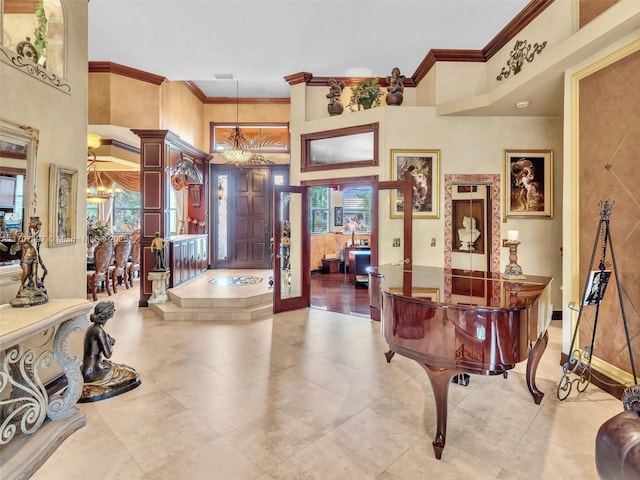 entryway with a towering ceiling, crown molding, and a notable chandelier