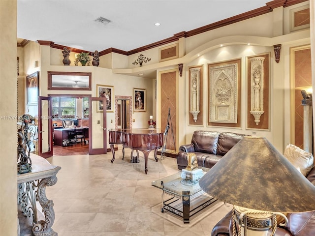 living room featuring baseboards, visible vents, and crown molding