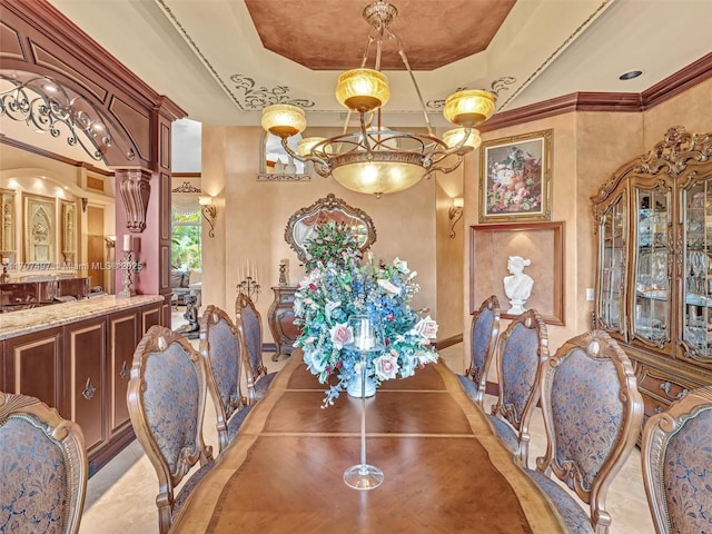 dining area with a raised ceiling, a high ceiling, crown molding, and decorative columns