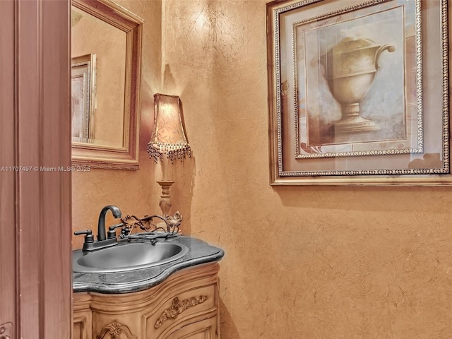 bathroom featuring a textured wall and vanity