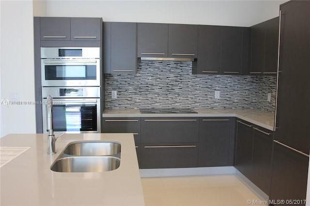 kitchen with sink, tasteful backsplash, double oven, and black electric cooktop