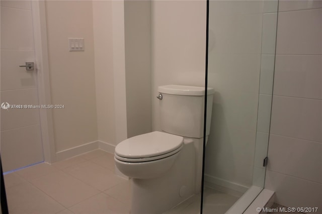 bathroom featuring tile patterned floors, toilet, and a shower