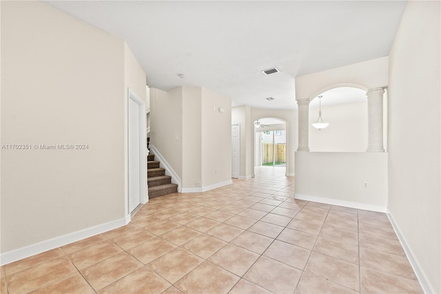 2557 SE 14th St, Homestead, FL 33035 - spare room with light tile patterned flooring, ornate columns, arched walkways, and stairway