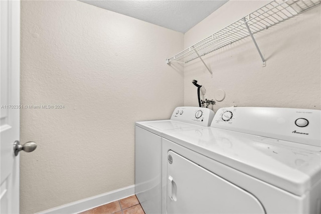 laundry area with separate washer and dryer and light tile patterned floors