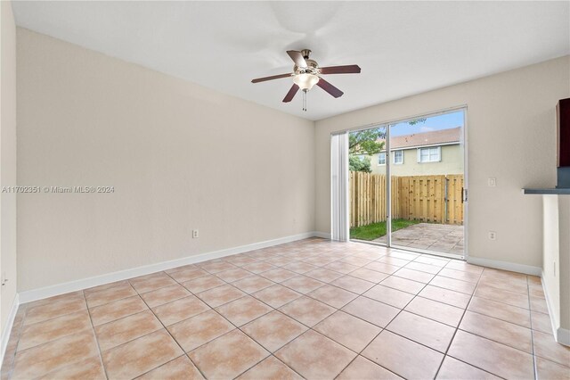 tiled empty room featuring ceiling fan