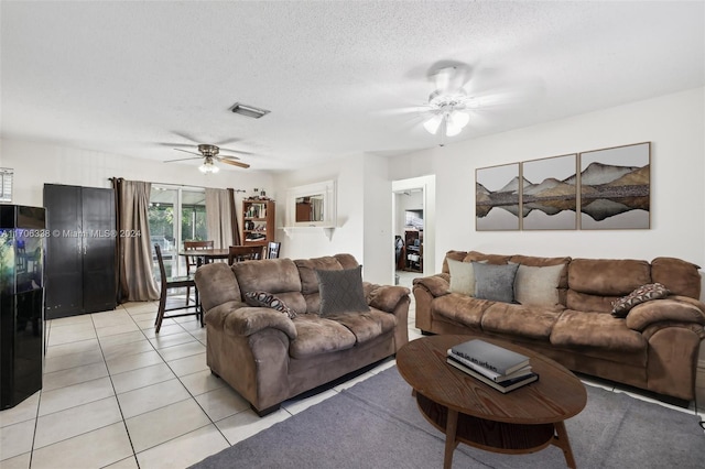 tiled living room with ceiling fan and a textured ceiling