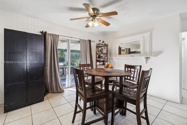 dining space featuring ceiling fan, light tile patterned floors, and a textured ceiling