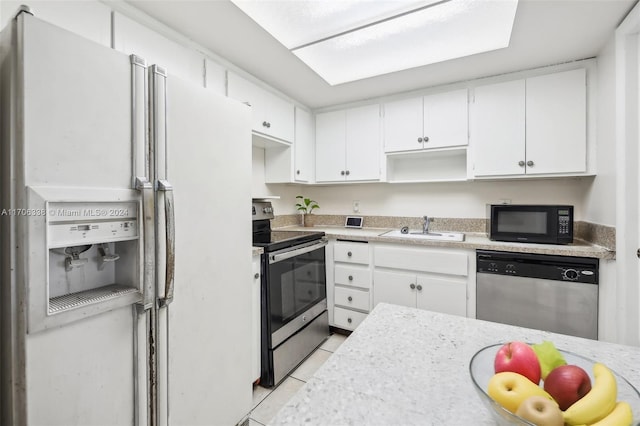 kitchen featuring light tile patterned flooring, sink, white cabinetry, and stainless steel appliances