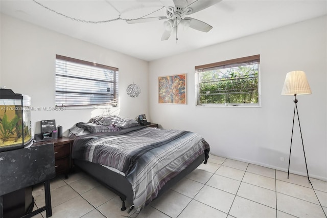 tiled bedroom with ceiling fan and multiple windows